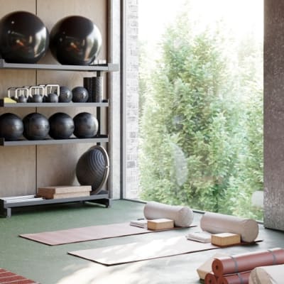 a room with yoga mats and a bookshelf with sculptures on it